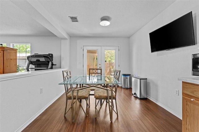 dining area with baseboards, dark wood-style flooring, french doors, and visible vents