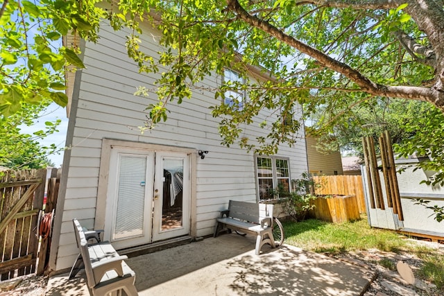 rear view of property featuring a patio, french doors, fence, and a gate
