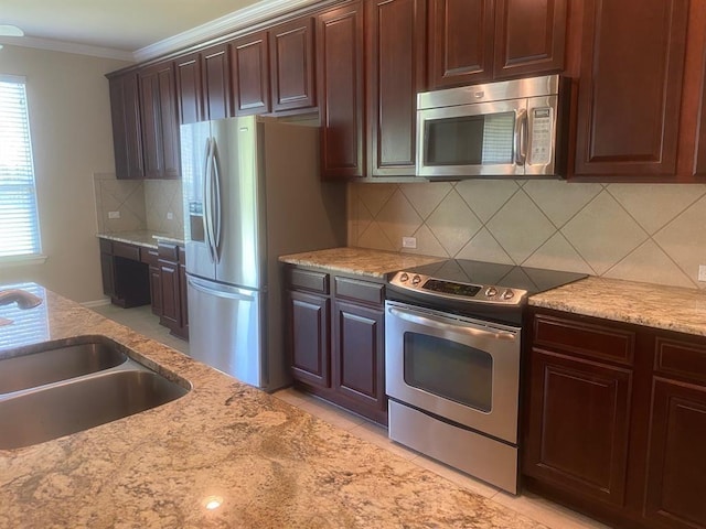 721 Independence Creek Ln, Georgetown, TX 78633 - kitchen with ornamental molding, stainless steel appliances, a sink, and light stone countertops