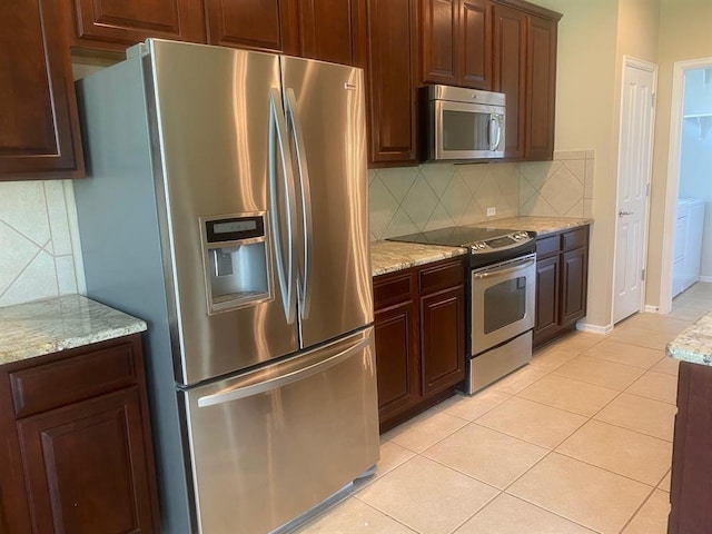 721 Independence Creek Ln, Georgetown, TX 78633 - kitchen featuring stainless steel appliances, tasteful backsplash, light stone counters, and light tile patterned floors