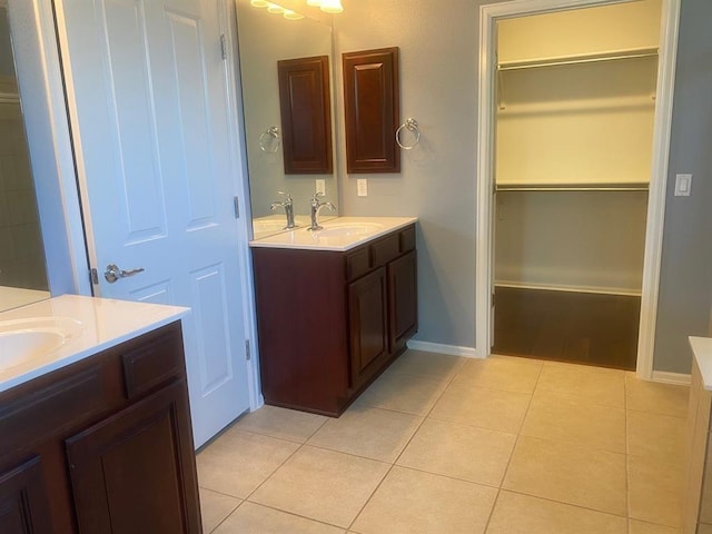 721 Independence Creek Ln, Georgetown, TX 78633 - full bathroom featuring a sink, tile patterned floors, a walk in closet, two vanities, and baseboards