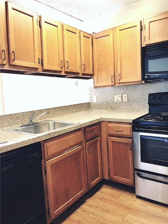 2210 Pearl St Unit 304, Austin, TX 78705 - kitchen with a sink, light wood-style flooring, light countertops, and black appliances