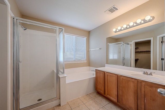 7725 Buckmeadow Dr, Georgetown, TX 78628 - bathroom with a stall shower, tile patterned flooring, a garden tub, vanity, and a walk in closet