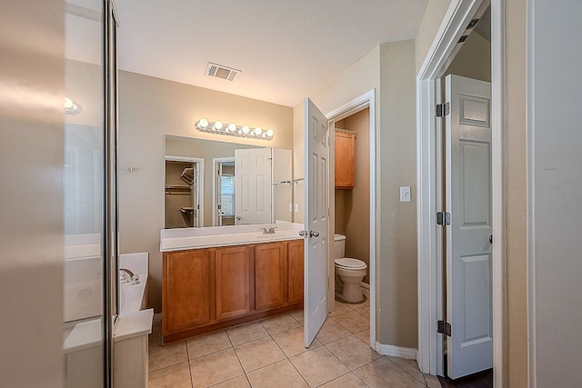 7725 Buckmeadow Dr, Georgetown, TX 78628 - full bath featuring toilet, visible vents, tile patterned flooring, vanity, and a spacious closet