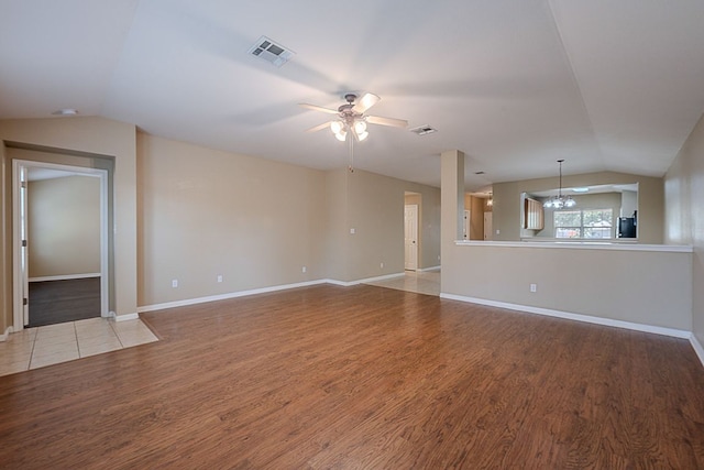 7725 Buckmeadow Dr, Georgetown, TX 78628 - unfurnished living room with vaulted ceiling, ceiling fan, light wood finished floors, a chandelier, and baseboards