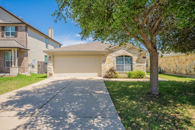 13605 James Garfield St, Manor, TX 78653 - view of front of house featuring stone siding, a garage, fence, concrete driveway, and a front yard