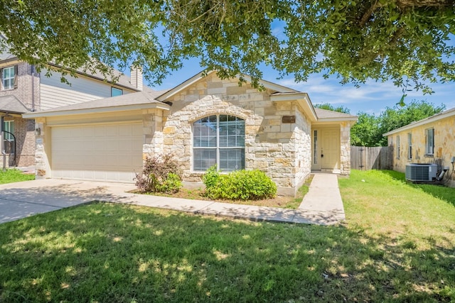 13605 James Garfield St, Manor, TX 78653 - view of front of house with stone siding, an attached garage, fence, a front lawn, and central air condition unit
