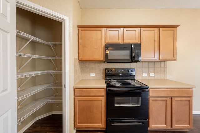 13605 James Garfield St, Manor, TX 78653 - kitchen featuring baseboards, dark wood finished floors, decorative backsplash, black appliances, and light countertops