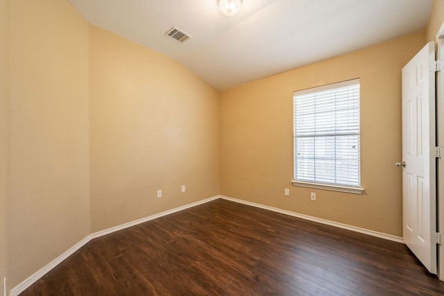 13605 James Garfield St, Manor, TX 78653 - unfurnished bedroom with baseboards, lofted ceiling, visible vents, and dark wood-type flooring