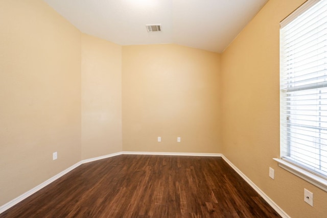 13605 James Garfield St, Manor, TX 78653 - empty room with baseboards, visible vents, dark wood-style flooring, and lofted ceiling