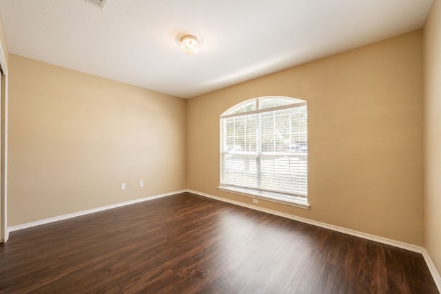 13605 James Garfield St, Manor, TX 78653 - spare room featuring dark wood-style flooring and baseboards