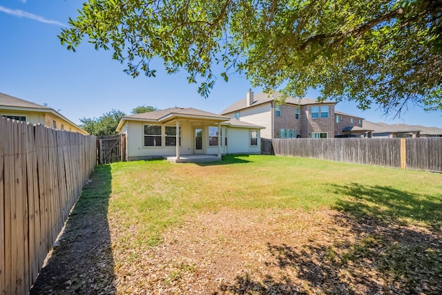 13605 James Garfield St, Manor, TX 78653 - rear view of house featuring a lawn, stucco siding, and a fenced backyard