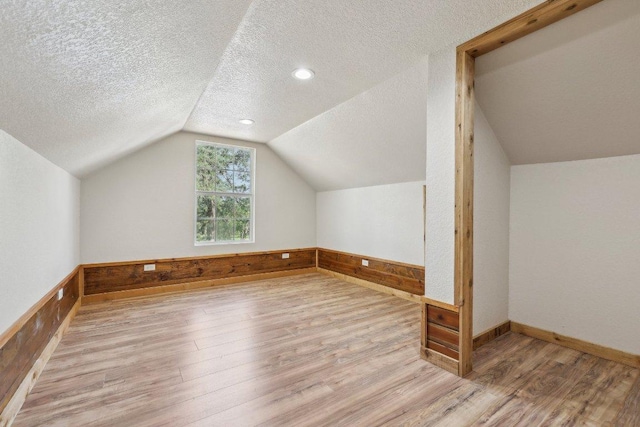 1200 County Road 211, Giddings, TX 78942 - bonus room with lofted ceiling, a textured ceiling, wainscoting, wooden walls, and wood finished floors