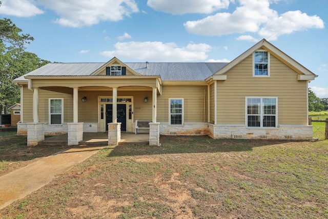 1200 County Road 211, Giddings, TX 78942 - view of front of house with stone siding, a porch, metal roof, and a front lawn