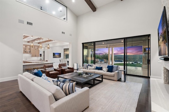 5609 Laceback Ter, Austin, TX 78738 - living area featuring beamed ceiling, a high ceiling, wood finished floors, a chandelier, and a fireplace