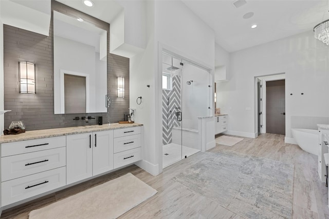 5609 Laceback Ter, Austin, TX 78738 - bathroom with vanity, a shower stall, a freestanding bath, backsplash, and recessed lighting