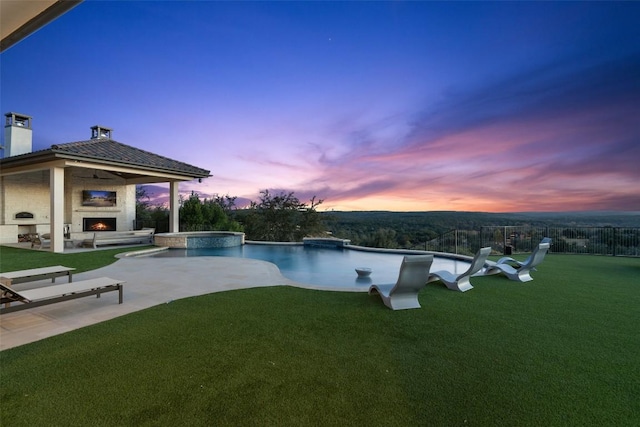 5609 Laceback Ter, Austin, TX 78738 - pool at dusk featuring a warm lit fireplace, a patio, and a pool with connected hot tub