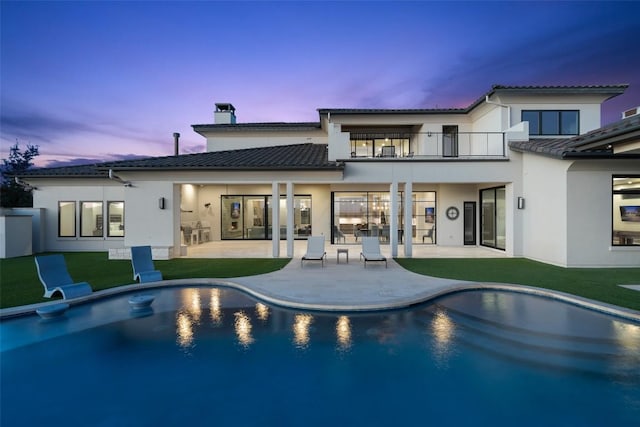 5609 Laceback Ter, Austin, TX 78738 - rear view of house with a balcony, a patio, stucco siding, an outdoor pool, and a chimney