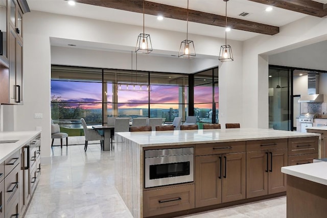 5609 Laceback Ter, Austin, TX 78738 - kitchen featuring wall chimney range hood, pendant lighting, beamed ceiling, glass insert cabinets, and a center island