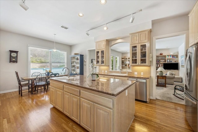 kitchen with an island with sink, a sink, light brown cabinets, visible vents, and appliances with stainless steel finishes