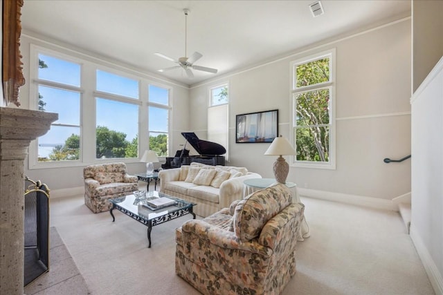 living room with carpet, baseboards, a ceiling fan, and visible vents