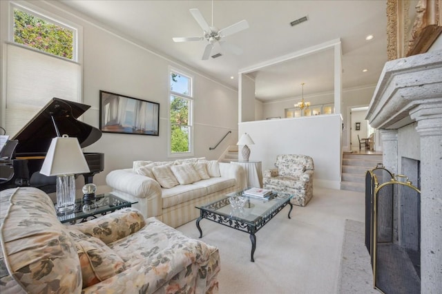 carpeted living area featuring crown molding, visible vents, a ceiling fan, and stairs