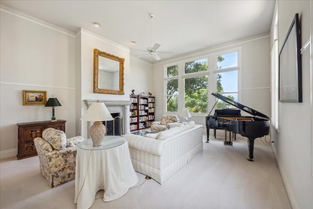 living room featuring a fireplace, ceiling fan, crown molding, and light colored carpet