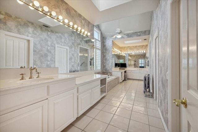 full bathroom featuring a sink, visible vents, tile patterned floors, a garden tub, and wallpapered walls