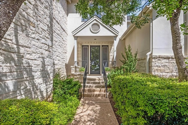 entrance to property with stucco siding and stone siding