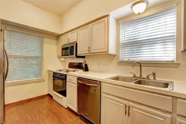 2208 Trailside Dr, Austin, TX 78704 - kitchen with a sink, stainless steel appliances, light countertops, and light wood-style floors