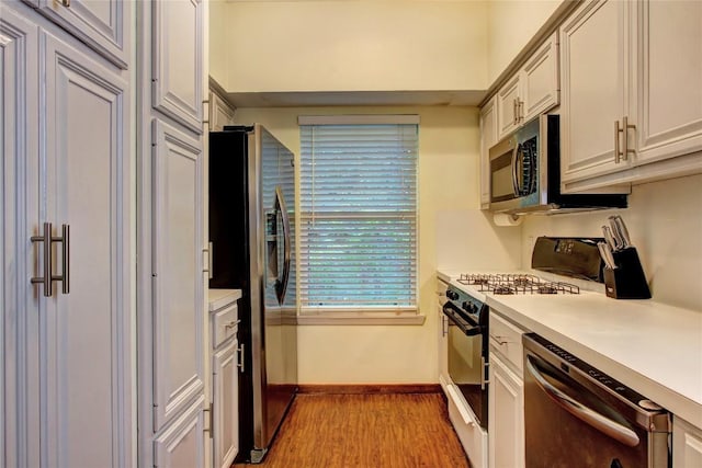 2208 Trailside Dr, Austin, TX 78704 - kitchen with light wood-type flooring, stainless steel appliances, light countertops, and baseboards