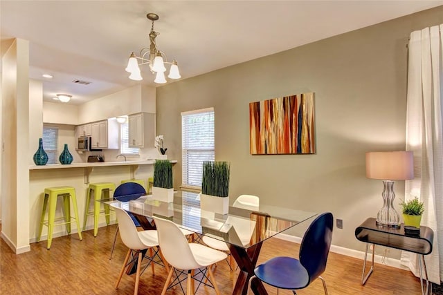 2208 Trailside Dr, Austin, TX 78704 - dining room with baseboards, a notable chandelier, light wood-style flooring, and visible vents