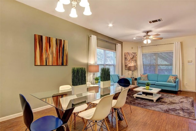 2208 Trailside Dr, Austin, TX 78704 - dining space with ceiling fan with notable chandelier, baseboards, visible vents, and wood finished floors