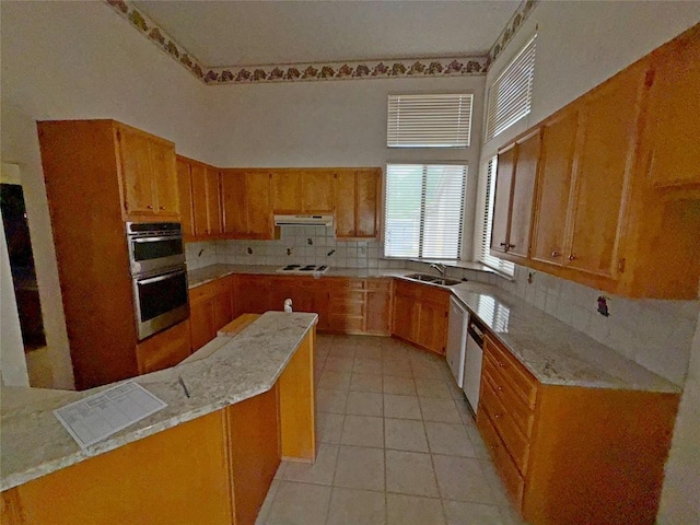 kitchen featuring light tile patterned floors, a sink, extractor fan, backsplash, and white cooktop