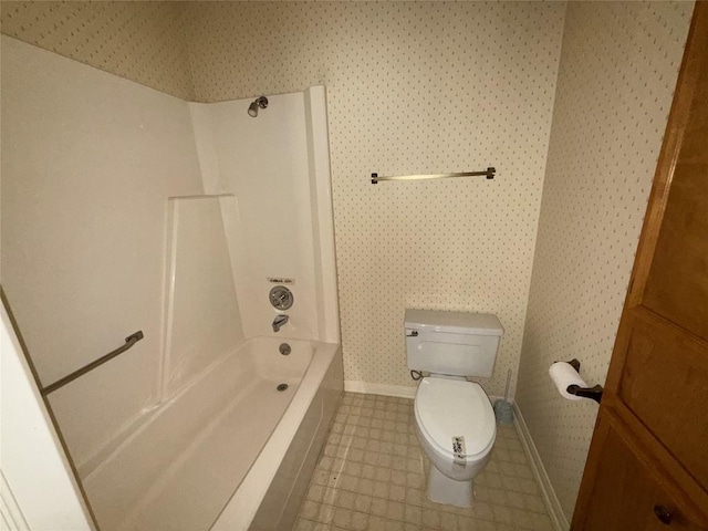 bathroom with toilet, tub / shower combination, wallpapered walls, baseboards, and tile patterned flooring