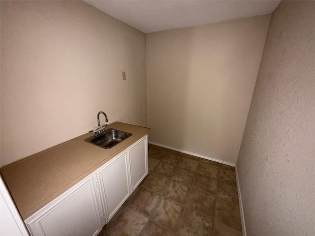 laundry area with a sink and baseboards
