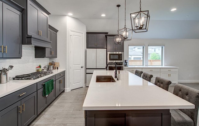 6320 Lipan Bayou Trl, Austin, TX 78738 - kitchen featuring stainless steel appliances, tasteful backsplash, a kitchen island with sink, light wood-style flooring, and a breakfast bar area