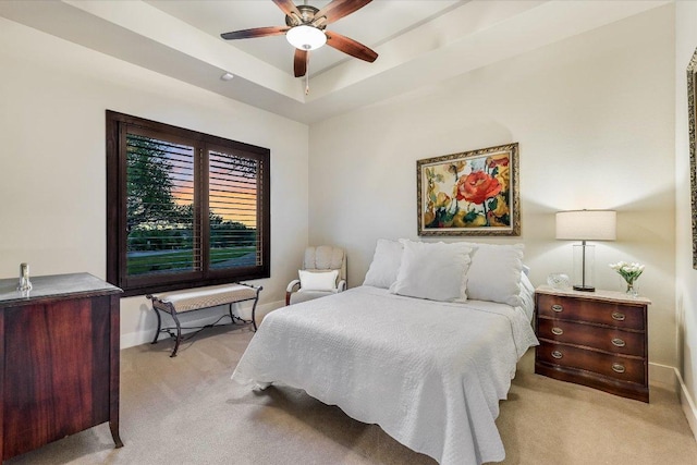 bedroom with a tray ceiling, baseboards, a ceiling fan, and carpet floors