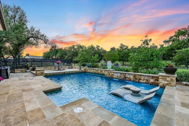 pool at dusk with a patio and a fenced backyard