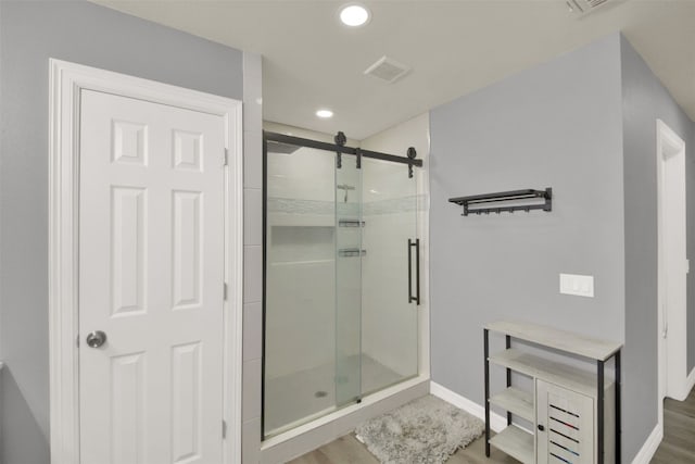 bathroom featuring visible vents, wood finished floors, a shower stall, and recessed lighting