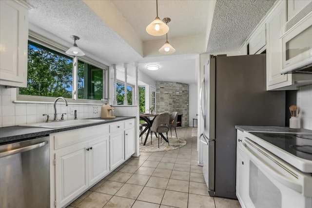 9010 Quail Creek Dr, Austin, TX 78758 - kitchen with a textured ceiling, white appliances, a sink, decorative backsplash, and dark countertops