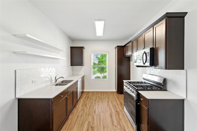 7013 Tonka Ln, Austin, TX 78744 - kitchen with stainless steel appliances, open shelves, a sink, dark brown cabinetry, and light wood-style floors