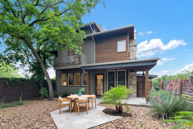 310 Terrace Dr Unit B, Austin, TX 78704 - back of property featuring a balcony, fence, a patio area, and stone siding