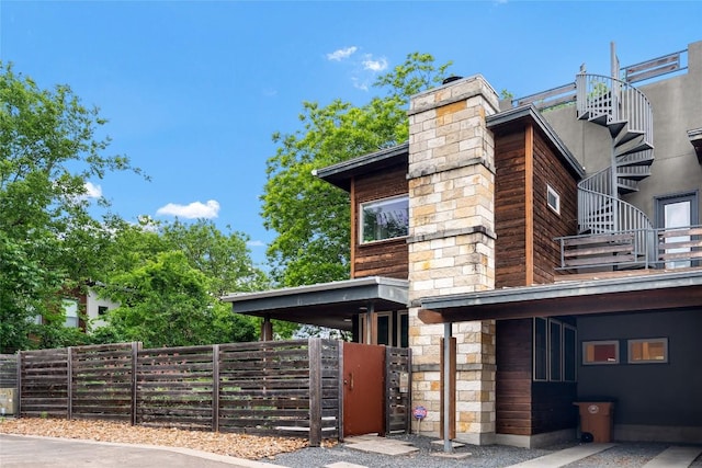 310 Terrace Dr Unit B, Austin, TX 78704 - view of property exterior with fence, a chimney, stone siding, and a balcony