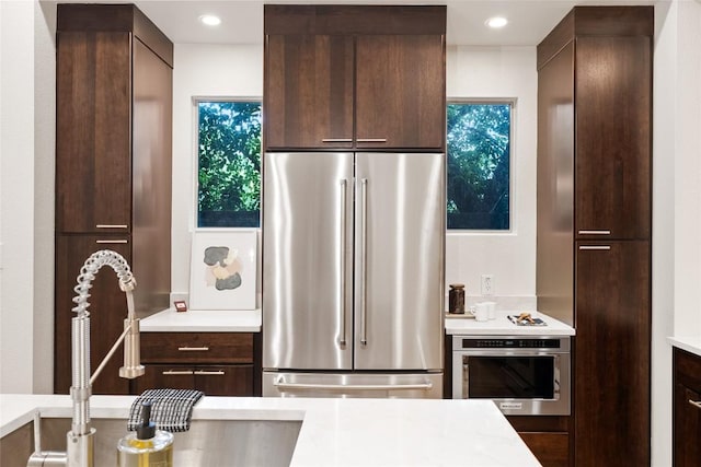 310 Terrace Dr Unit B, Austin, TX 78704 - kitchen featuring stainless steel appliances, a sink, dark brown cabinets, modern cabinets, and light countertops