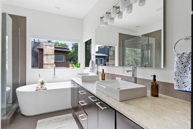 310 Terrace Dr Unit B, Austin, TX 78704 - full bath featuring double vanity, a freestanding tub, a stall shower, tile patterned flooring, and tasteful backsplash