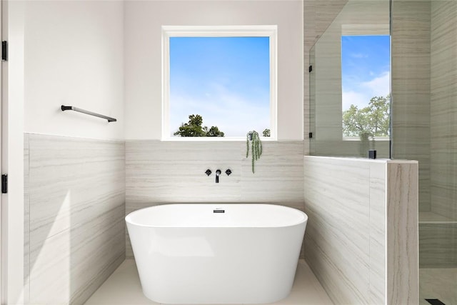 1702 Pennsylvania Ave, Austin, TX 78702 - bathroom with a soaking tub and tile walls