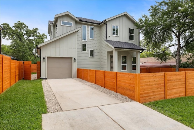 1702 Pennsylvania Ave, Austin, TX 78702 - view of front of house with board and batten siding, driveway, a fenced front yard, and a garage