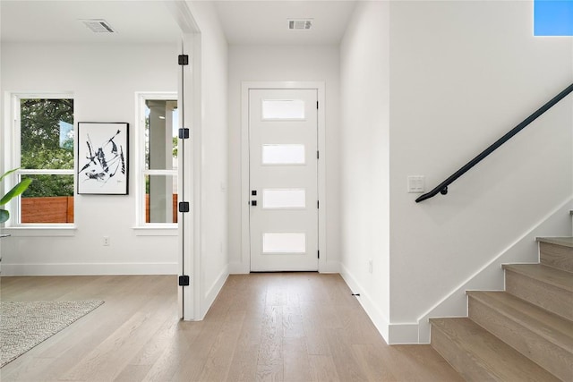 1702 Pennsylvania Ave, Austin, TX 78702 - foyer entrance featuring light wood-style floors, stairs, and baseboards