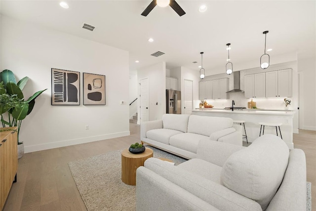 1702 Pennsylvania Ave, Austin, TX 78702 - living room with ceiling fan, recessed lighting, stairs, light wood-style floors, and baseboards
